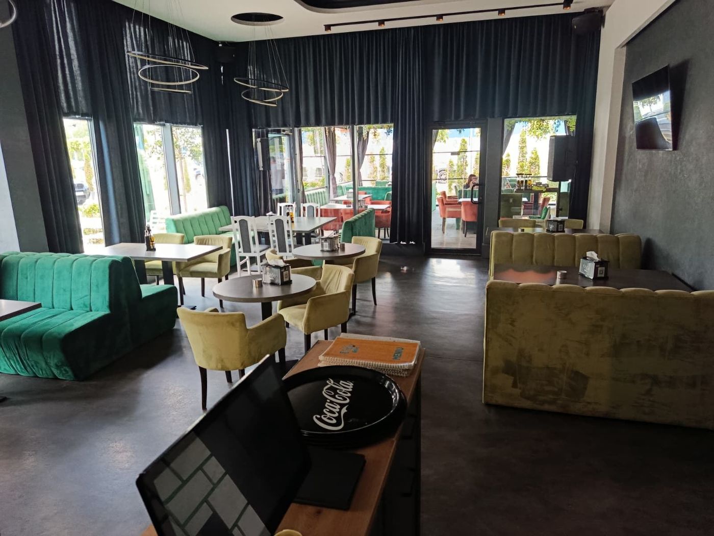 Interiorul restaurantului Vivo Bistro, cu banchete verzi de catifea și lumină naturală